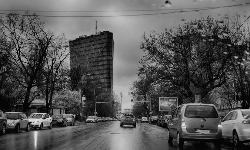 a black and white photo of a city street, a black and white photo, by Sven Erixson, flickr, brutalism, dieselpunk volgograd, driving rain, springtime, shot on sony a 7