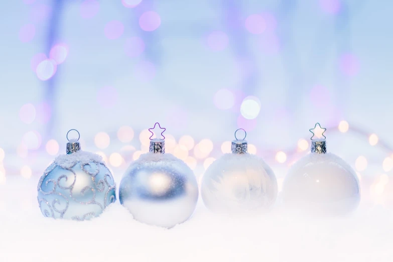 a row of christmas ornaments sitting on top of a snow covered ground, a photo, by Maksimilijan Vanka, shutterstock, minimalism, soft purple glow, blue! and white colors, 🤬 🤮 💕 🎀, white and silver