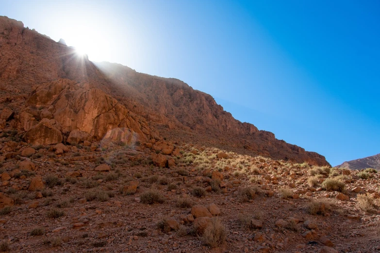 the sun shines brightly on the side of a mountain, les nabis, desert transition area, shot on a 9.8mm wide angle lens, flaming mountain, time to climb the mountain path