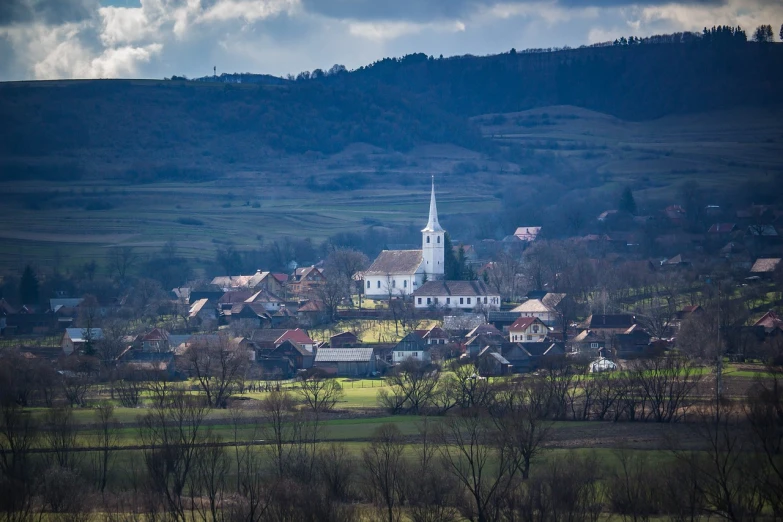 a large white church sitting on top of a lush green hillside, a tilt shift photo, by Hristofor Žefarović, shutterstock, large landscape with village, springtime morning, february), stock photo