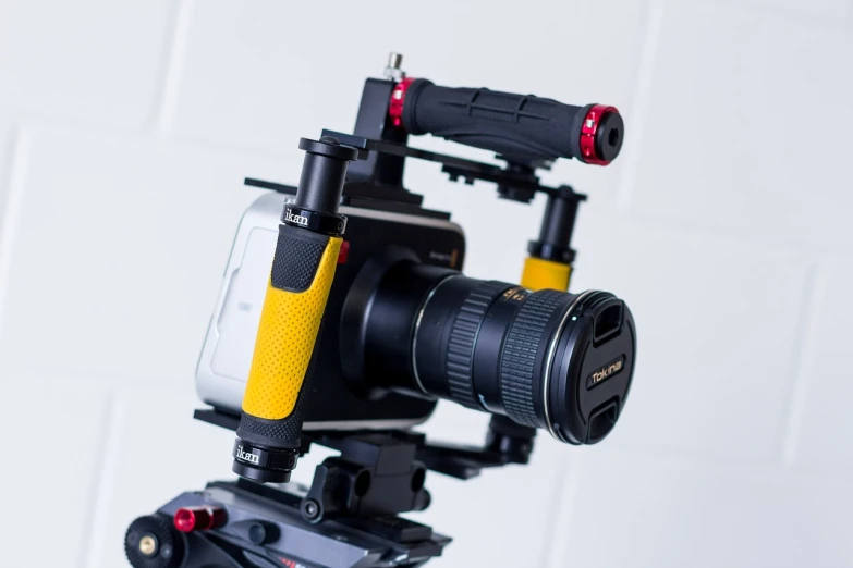 a close up of a camera on a tripod, dau-al-set, black and yellow and red scheme, phantom grip, smartphone footage, dslr 24mm