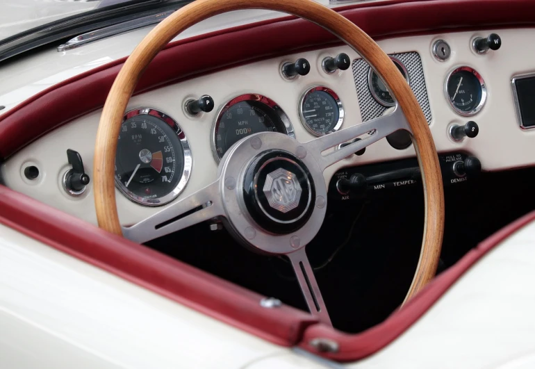 a close up of a steering wheel and dashboard of a car, by David Simpson, hypermodernism, maroon and white, classic cars, white color scheme, hurricane