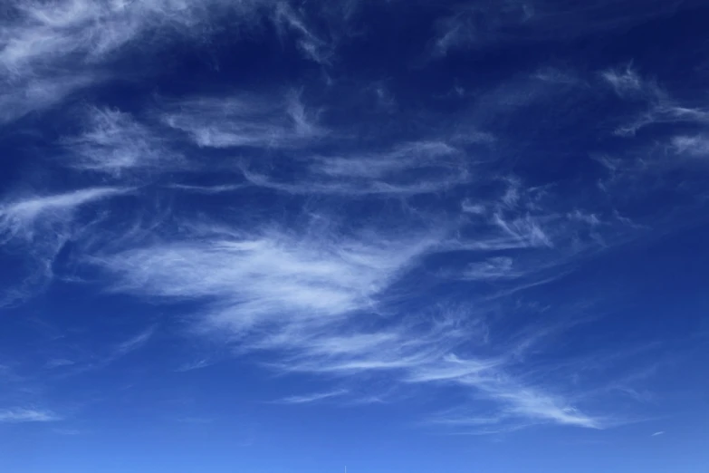 a man riding a snowboard on top of a snow covered slope, shutterstock, romanticism, sky mural on the room ceiling, layered stratocumulus clouds, wispy clouds in a blue sky, wispy tendrils of smoke