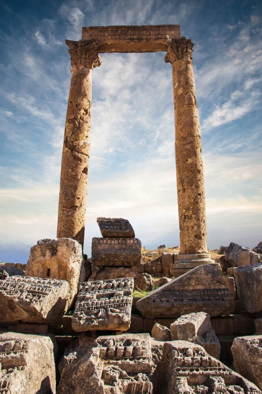 a large stone structure sitting on top of a hill, a picture, by Julian Allen, shutterstock, greek-esque columns and ruins, al - qadim, apollo, battered