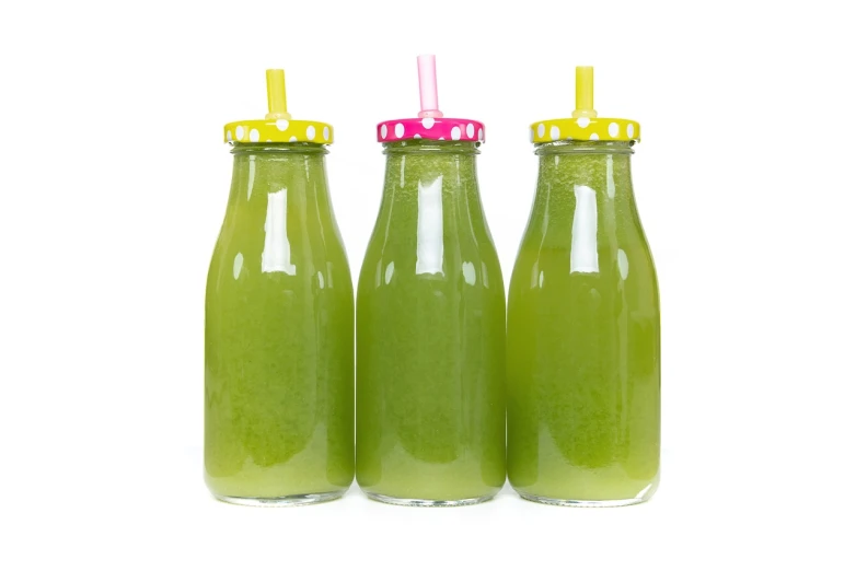 three bottles of green juice sitting next to each other, a photo, by Harold Elliott, shutterstock, isolated on white background, carnival, freezing, pregnancy