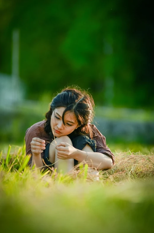 a woman laying on top of a lush green field, a picture, shutterstock, realism, female actress from korea, side portrait rugged girl, scene from live action movie, the anime girl is crouching