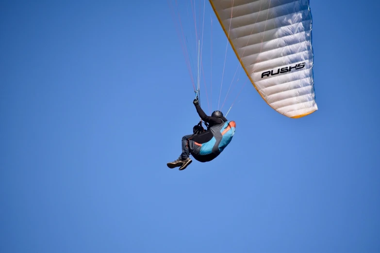 a man flying through the air while holding onto a parachute, a picture, by Jan Rustem, shutterstock, taken with canon 8 0 d, ornithopter, blog-photo, aerodynamic body