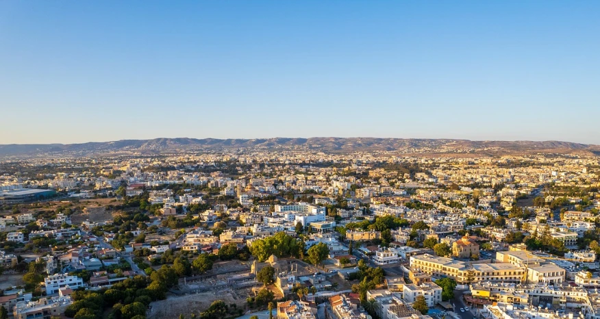 an aerial view of a city with mountains in the background, shutterstock, cyprus, ultra wide-shot, warm light, on a bright day