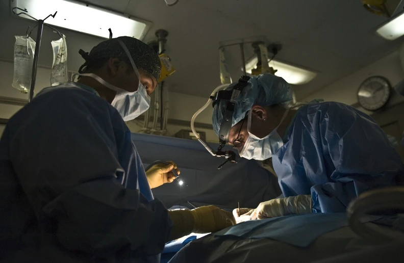 two surgeons performing surgery in an operating room, by Ken Elias, flickr, hurufiyya, back - lit, journalistic photo, vtm, uncropped