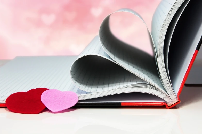 a close up of a book with a heart cut out of it, a picture, notebook, ad image, pen, hearts