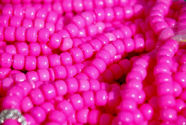 a pile of pink beads sitting on top of a table, a macro photograph, rasquache, highly detailed product photo, ((neon colors)), close-up product photo, demna gvasalia