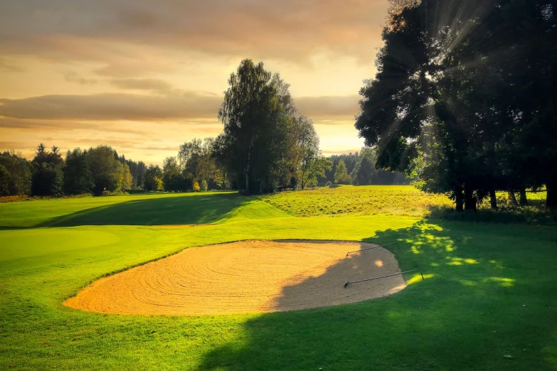 a golf course with a sand bunker and trees in the background, by Thomas Häfner, shutterstock, filtered evening light, wallpaper - 1 0 2 4, midlands, awards winning