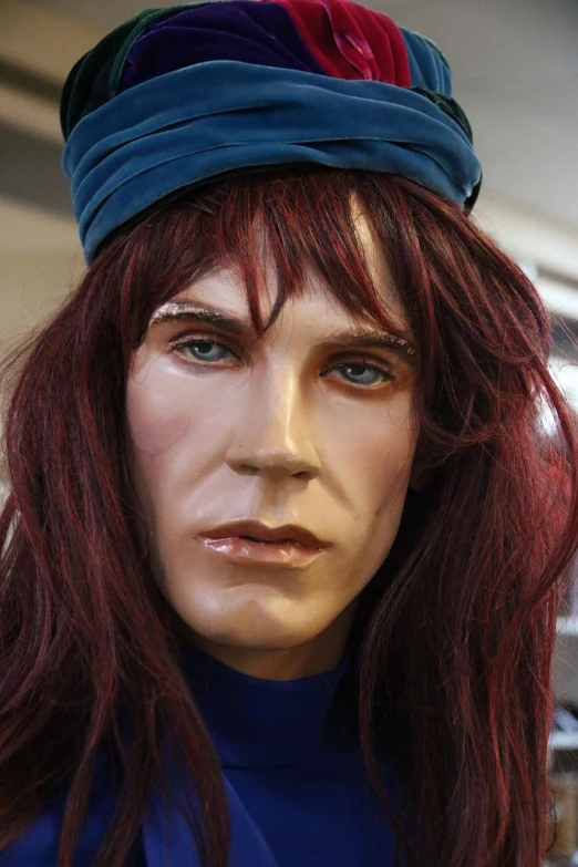 a close up of a mannequin wearing a hat, a portrait, fantastic realism, long shaggy red hair, blue-eyed man, transgender, purple mullet