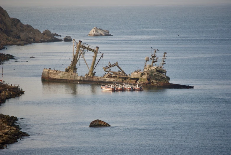 a ship that is sitting in the water, by Raymond Normand, flickr, chile, sunken, crab, grain”