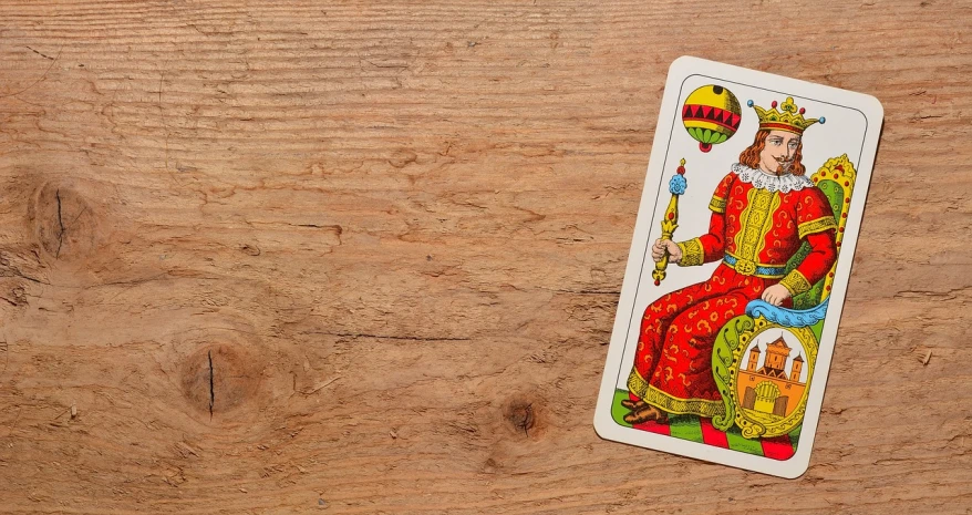 a playing card sitting on top of a wooden table, a stock photo, by Matthias Stom, trending on pixabay, figuration libre, indian empress, a brightly coloured, website banner, rider-waite tarot