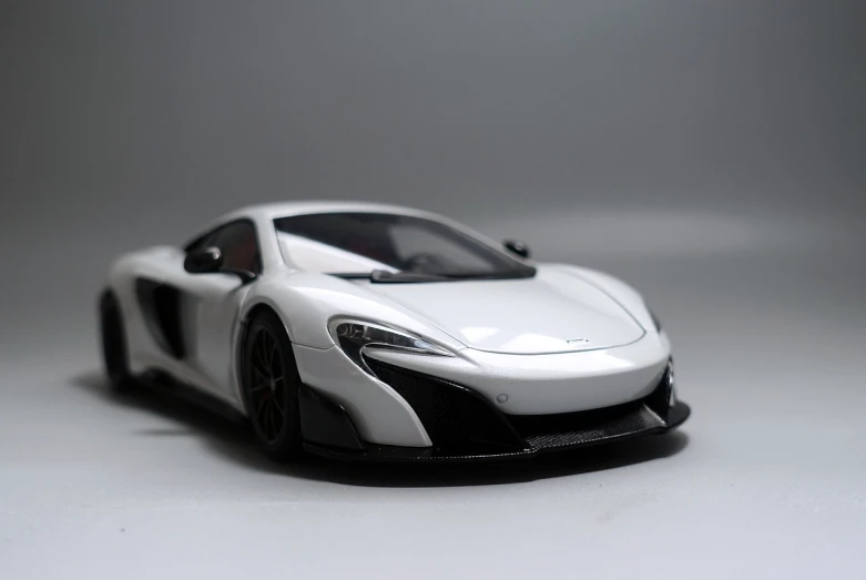 a close up of a toy car on a table, a picture, unsplash, photorealism, mclaren, white on black, ultra _ realistic, full front view