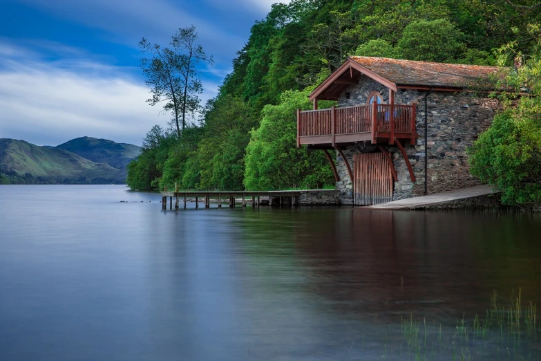 a building sitting on top of a lake next to a forest, by John Murdoch, pexels contest winner, luxurious wooden cottage, fine detail post processing, john waterhouse, at the waterside