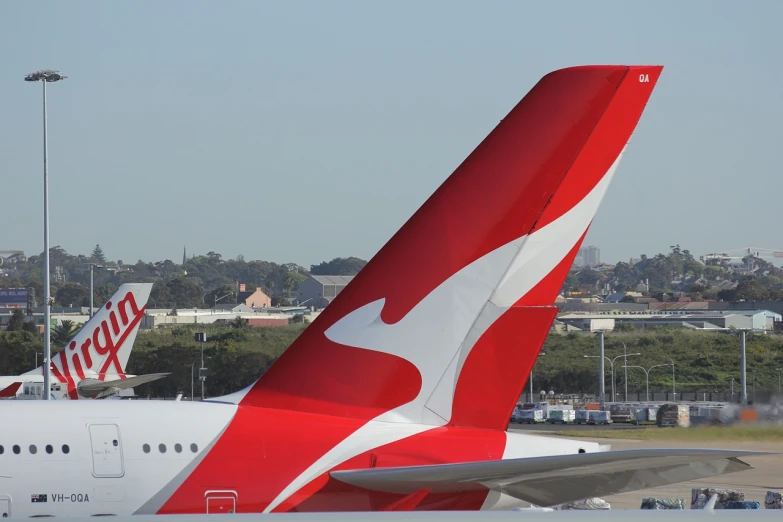 a large jetliner sitting on top of an airport tarmac, a picture, by Matt Stewart, hurufiyya, red and white color scheme, kangaroo, side view close up of a gaunt, tail slightly wavy