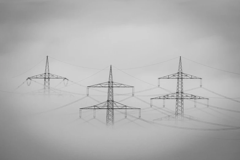 a black and white photo of power lines in the fog, by Adam Marczyński, precisionism, today\'s featured photograph 4k, three towers, hyperdetailed!, in a row