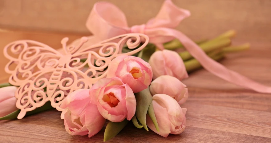 a bunch of pink tulips sitting on top of a wooden table, ornamental bow, 3 4 5 3 1, with soft pink colors, exquisite handle