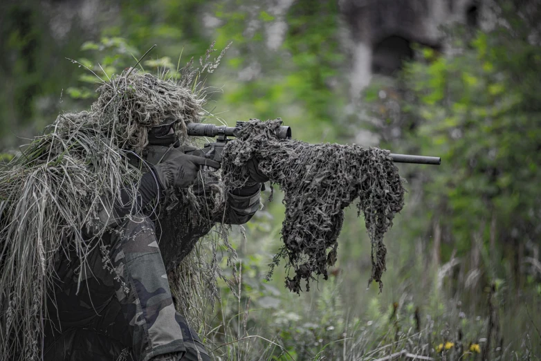 a man that is standing in the grass with a rifle, mesh roots. closeup, high quality product image”