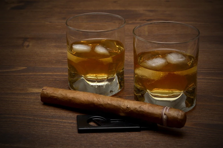 two glasses of whiskey and a cigar cutter on a table, inspired by William Grant Stevenson, shutterstock, stock photo, high res photo, cuba, hurricane