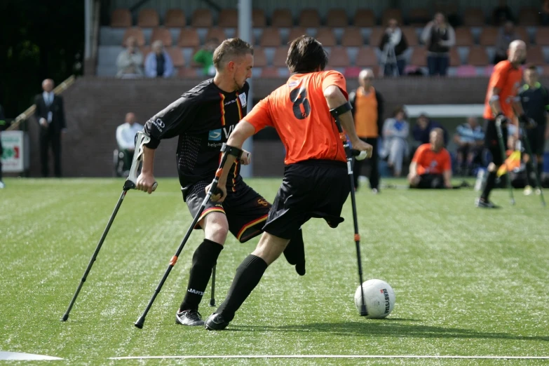 a couple of men playing a game of soccer, a photo, by Jan Tengnagel, flickr, figuration libre, crutches, in a race competition, bionics, the photo shows a large