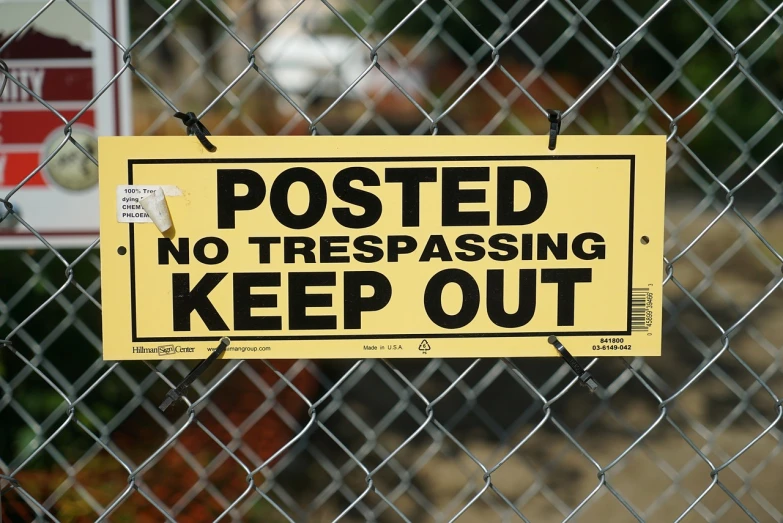 a yellow sign that says posted no trespassing keep out, by Randy Post, graffiti, getty images, ( ( emma lindstrom ) ), nongraphic, maze