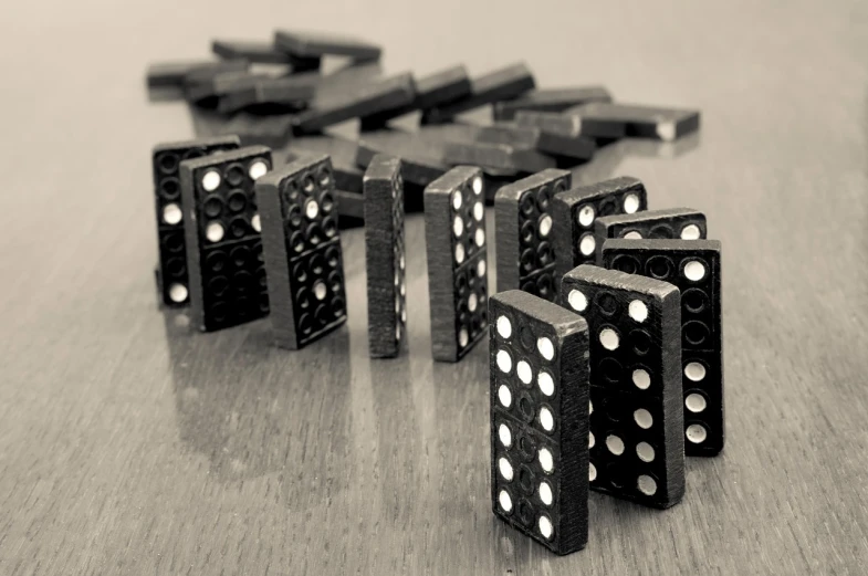 a group of dominos sitting on top of a wooden table, a macro photograph, digital art, monochrome hdr, 1940s photo