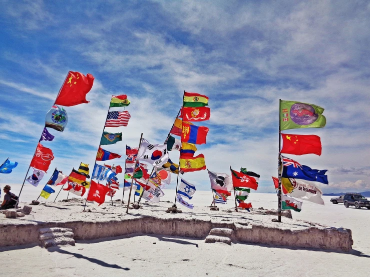 a group of flags sitting on top of a sandy beach, a portrait, pexels, snow, high altitude, several continents, antilous chao