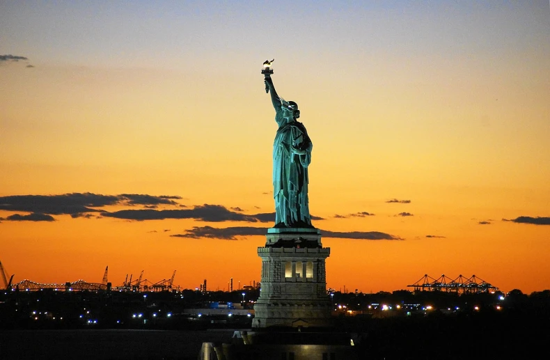 the statue of liberty is lit up at night, by Dennis Flanders, pexels, art nouveau, light illumination at sunset, wikimedia, taken with my nikon d 3, statue of a perfect woman