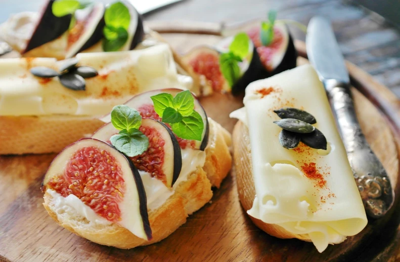 a cutting board topped with slices of bread covered in cheese and figs, by Juan Giménez, shutterstock, baking french baguette, fantasy food, glazed, mozzarella