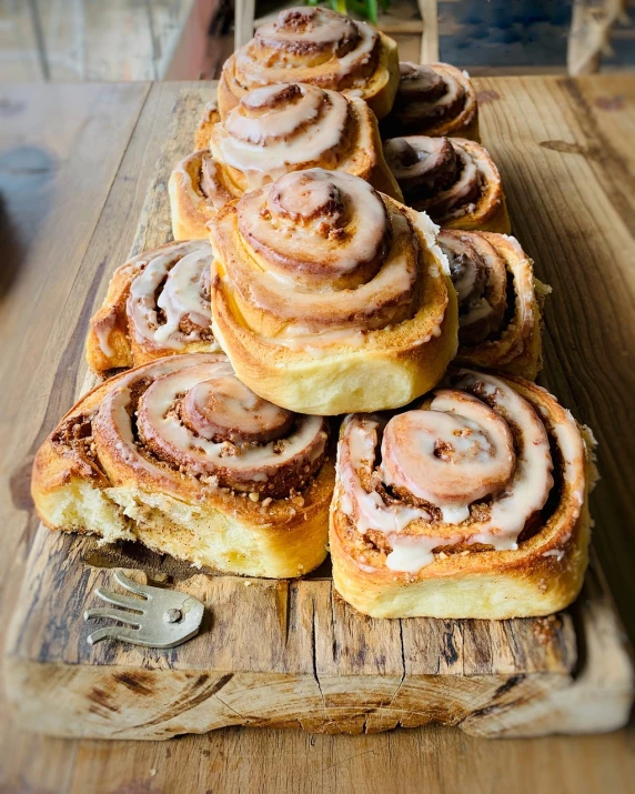 a pile of cinnamon rolls sitting on top of a wooden cutting board, a portrait, pexels, gradient brown to silver, on a bright day, 🦩🪐🐞👩🏻🦳, stacked image