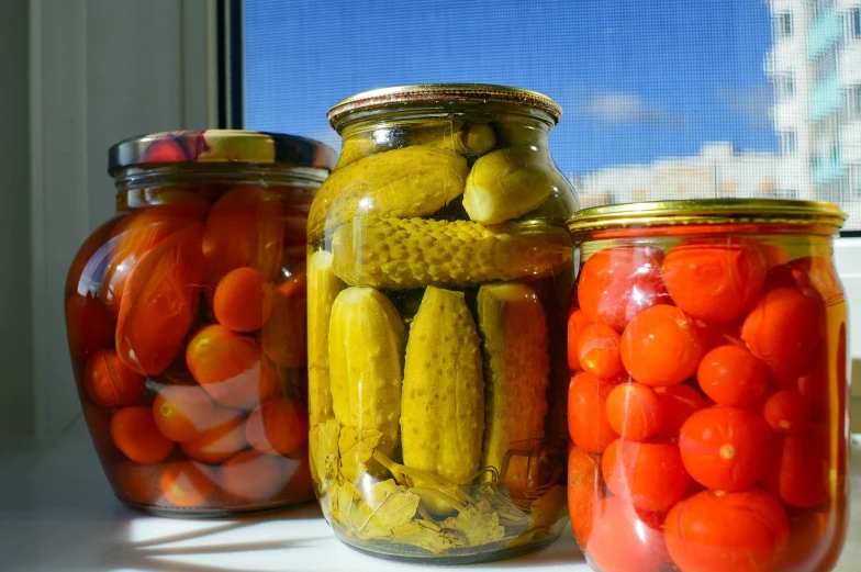 three jars of pickles and tomatoes sit on a window sill, by Aleksander Gierymski, pixabay, bauhaus, buds, saws, amber, photograph credit: ap