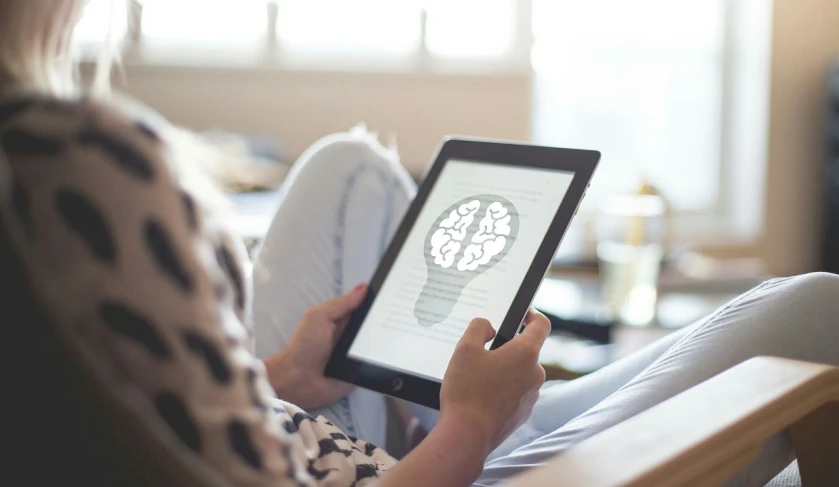 a woman sitting in a chair using a tablet computer, a digital rendering, pixabay, featuring brains, natural lighting, photograph credit: ap, everything fits on the screen