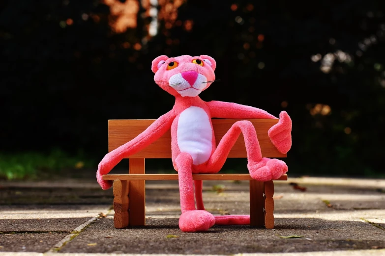 a pink stuffed animal sitting on top of a wooden bench, a picture, inspired by Leo Leuppi, pexels, realism, tony the tiger, fully posable, based on a puma, high res photo