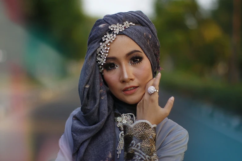 a woman in a hijab talking on a cell phone, by Basuki Abdullah, tumblr, hurufiyya, covered in jewels, with grey skin, beautiful asian girl, sarong
