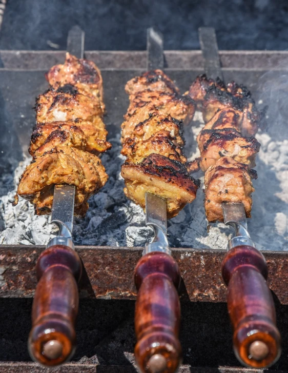 several skewers of meat cooking on a grill, shutterstock, dau-al-set, medieval feast, 33mm photo, 🦑 design, three fourths view