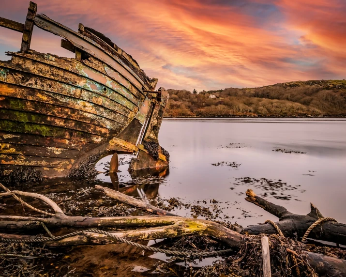 a boat sitting on top of a beach next to a body of water, a portrait, by Derek Chittock, shutterstock, decaying rich colors!, marsden, wide angle shot 4 k hdr, morning glow