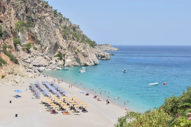 a beach filled with lots of people and umbrellas, a photo, by January Suchodolski, shutterstock, turkey, beach is between the two valleys, piroca, stock photo