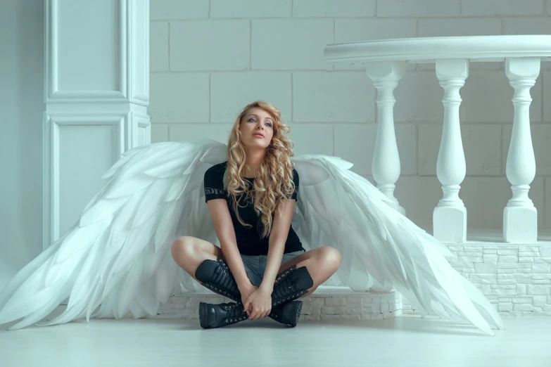 a woman with angel wings sitting on the floor, a portrait, trending on pixabay, aestheticism, ava max, katheryn winnick, white blouse and gothic boots, maxim sukharev