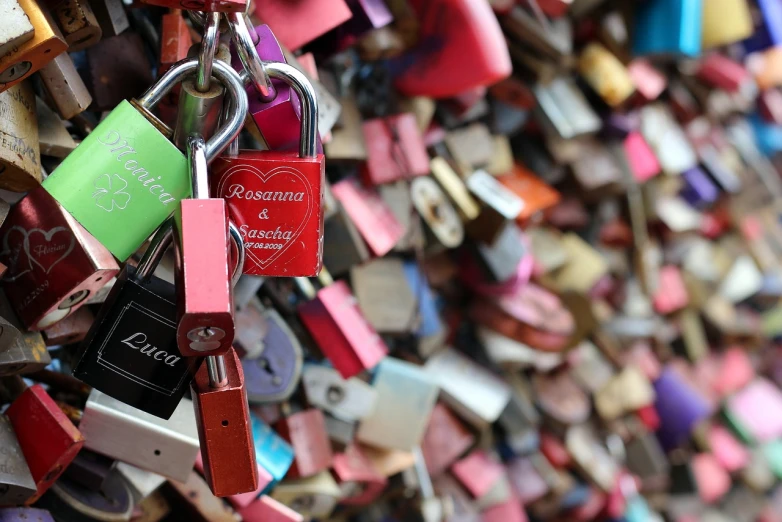 a bunch of padlocks attached to a wall, a photo, pexels, love is infinity, a colorful, blush, bridges