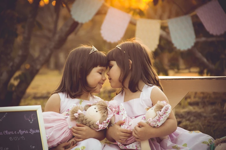 a couple of little girls sitting next to each other, by Lilia Alvarado, shutterstock, romanticism, romantic storybook fantasy, retro effect, lovely kiss, toy photo