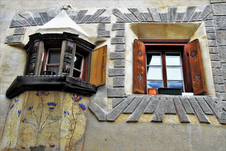 a close up of two windows on a building, by Karl Gerstner, flickr, in the dolomites, intricate graffiti, a quaint, tiles