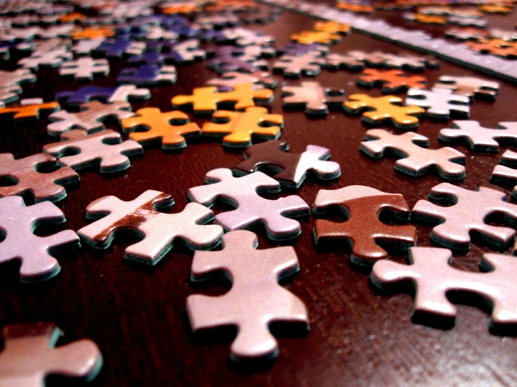 a pile of puzzle pieces sitting on top of a wooden table, a jigsaw puzzle, by Alexander Robertson, photorealism. trending on flickr, tabletop game board, detailed colors, cavities