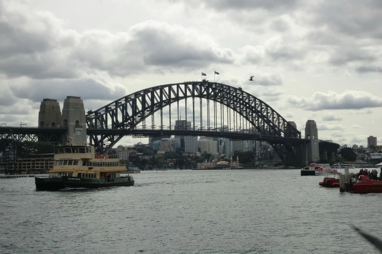 a large body of water with a bridge in the background, a picture, inspired by Sydney Carline, hurufiyya, the hard and strong buildings, slight overcast weather, it is very huge, port