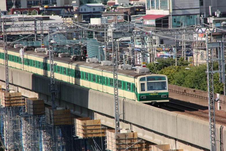 a green and white train traveling over a bridge, by Yanagawa Nobusada, flickr, gwanghwamun, 6 4 0, yard, -640