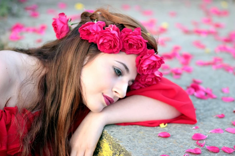 a woman in a red dress laying on a stone, trending on pixabay, romanticism, crown of peach roses, wearing a pink head band, attractive brown hair woman, flowers on heir cheeks