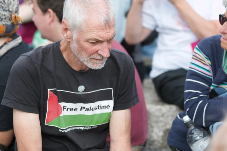 a group of people sitting next to each other, a photo, inspired by Pál Szinyei Merse, hurufiyya, wearing a tee shirt and combats, he has a devastated expression, iain mccaig, israel