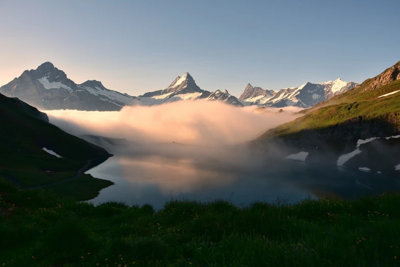 a body of water with mountains in the background, a picture, by Werner Andermatt, fog!!!, epic sunrise, swiss, gina heyer